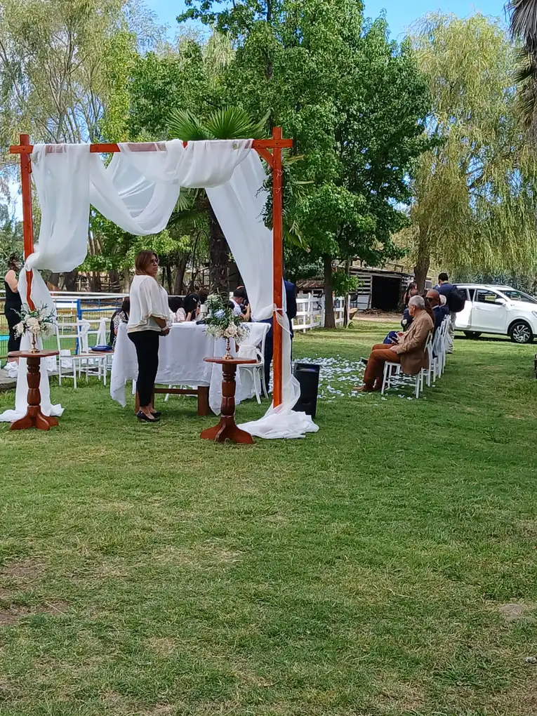 Arco con cortinas blancas para ceremonia sobre el césped