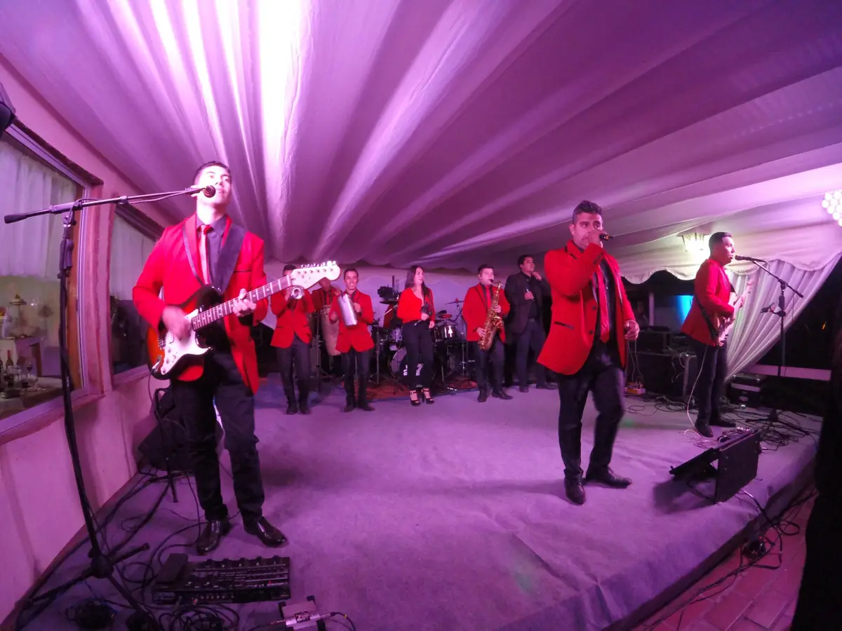 Grupo musical con vestuario rojo actuando en el escenario