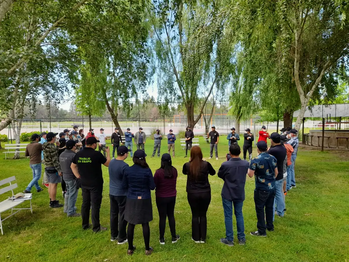Grupo de personas de pie en círculo sobre el césped